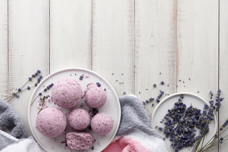 Natural cosmetics. Handmade lavender bath bombs, lavender flowers and towel on white wooden planks, top viewの写真素材