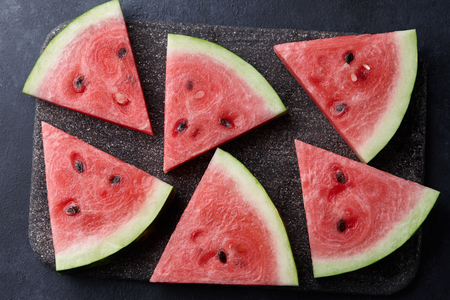 Fresh sliced watermelon on black stone background, top viewの写真素材