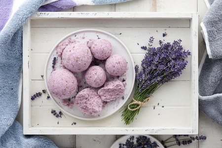 Handmade lavender bath bombs and lavender flowers in white tray, top viewの写真素材