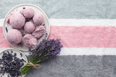 Handmade lavender bath bombs and lavender flowers on striped bath towel, top viewの写真素材