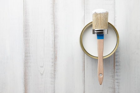 Can of white paint and brush on wooden planks, top viewの写真素材