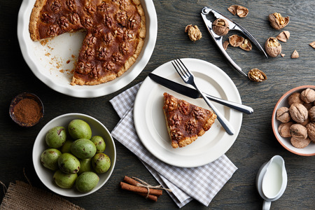 Traditional walnut pie with spices and nuts on dark wooden table, top viewの写真素材