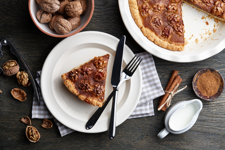 Traditional walnut pie with spices and nuts on dark wooden table, top viewの写真素材