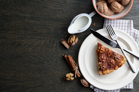 Traditional walnut pie with spices and nuts on dark wooden table, top viewの写真素材