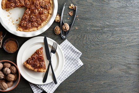 Traditional walnut pie with spices and nuts on dark wooden table, top viewの写真素材