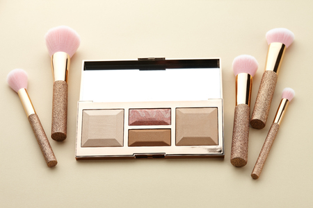 Make up palette and brushes on beige background, close up viewの写真素材