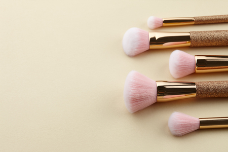 Make up brushes in a row close up on beige backgroundの写真素材