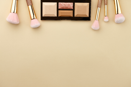 Make up palette and brushes on beige background, close up viewの写真素材