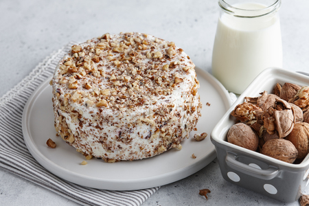 Round homemade goat cheese with walnuts and cranberriesの写真素材