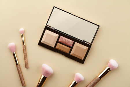 Make up palette and brushes on beige background, close up viewの写真素材
