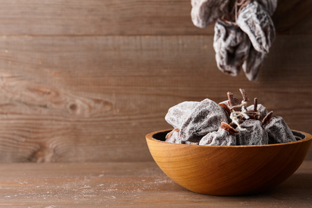 Dried persimmon in wooden bowl on planks background, close up viewの写真素材