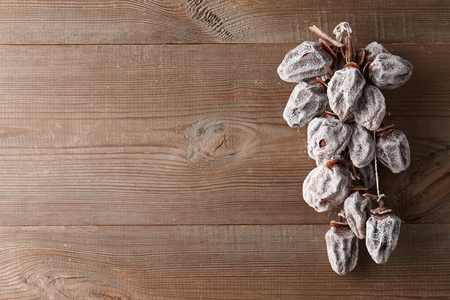 Hanging dried persimmon on old barn planks background, close up viewの写真素材