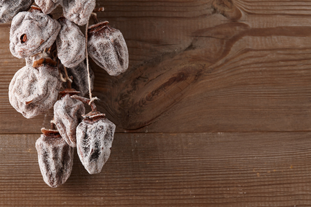 Hanging dried persimmon on old barn planks background, close up viewの写真素材