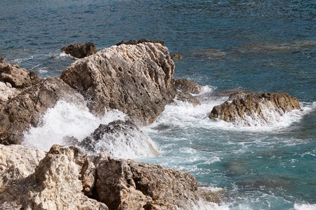 Sea waves crashing onto rocks with water splashes. Corfu island, Greece.の写真素材