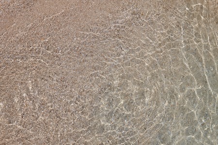 Sunbeams in shallow water. Abstract seashore background.の写真素材