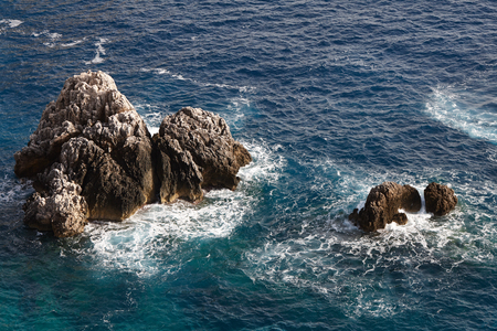 Sea waves crashing onto rocks with water splashes. Corfu island, Greece.の写真素材