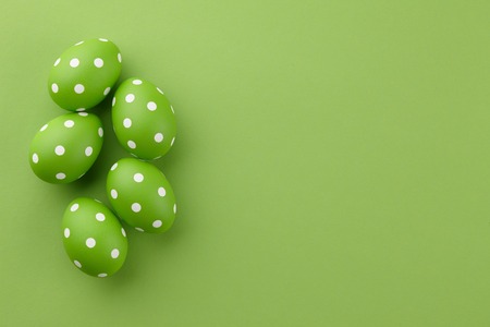 Green dotted Easter eggs on green background, copy spaceの写真素材