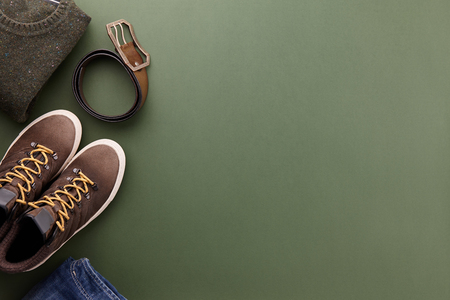 Mens fall casual clothing outfits and accessories flat lay on olive green background, top viewの写真素材