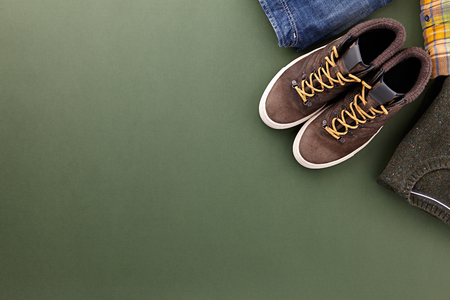 Mens fall casual clothing outfits and accessories flat lay on olive green background, top viewの写真素材