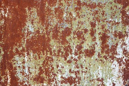 Vintage texture of old rusty metal sheet with cracking paint and chipping look. Antique background.