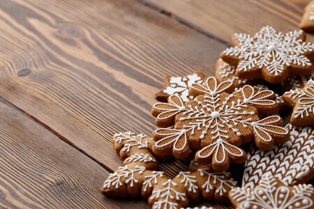 Christmas gingerbread cookies on brown wooden background, top view