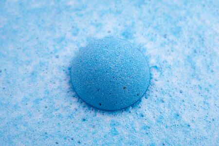 Blue bath bomb foaming in water, close up viewの写真素材