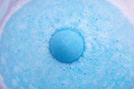 Blue bath bomb foaming in water, close up viewの写真素材