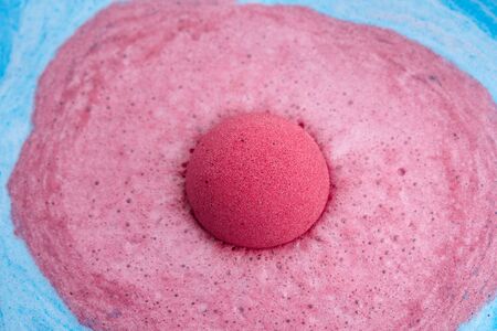 Pink bath bomb foaming in water, close up viewの写真素材