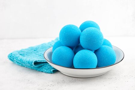 Blue bath bombs in plate on white tabletop, close up viewの写真素材