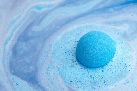 Blue bath bomb foaming in water, close up viewの写真素材