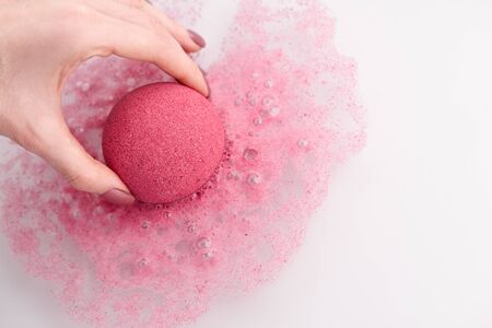 Woman's hand putting bath bomb into water, copy spaceの写真素材