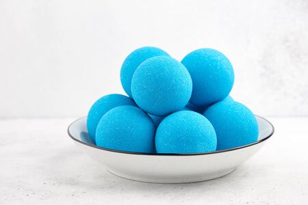 Blue bath bombs in plate on white tabletop, close up viewの写真素材