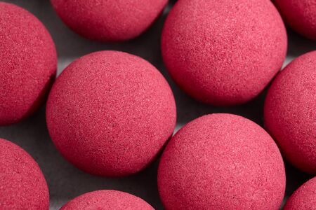 Pink bath bombs on gray tabletop, close up view