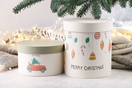 Gift boxes under Christmas tree on wool blanket and lights background, holiday concept