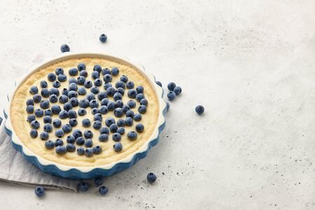 Blueberry pie or tart with fresh berries on white stone tabletopの写真素材