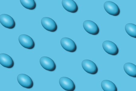 Trendy Easter pattern with blue eggs on blue background, holiday conceptの写真素材