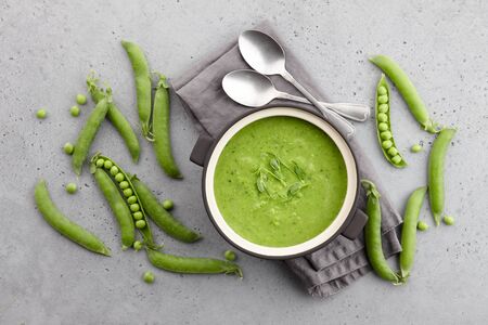 Fresh pea soup on gray concrete background, top viewの写真素材