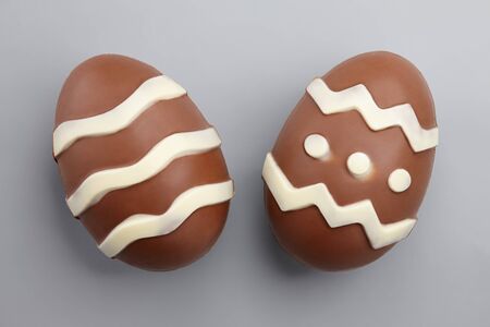 Two chocolate Easter eggs on gray background, close up viewの写真素材