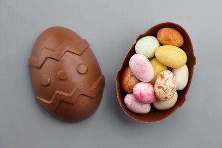 Chocolate Easter egg with colorful candies, holiday conceptの写真素材