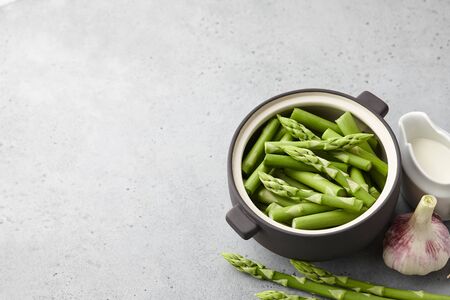 Fresh green asparagus in bowl on gray concrete background, copy spaceの写真素材