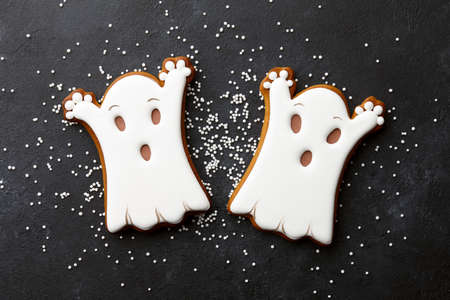 Halloween gingerbread biscuits on black background. Funny white ghosts.の写真素材