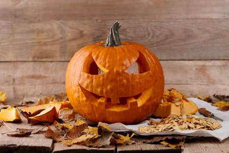 Carved Halloween pumpkin on wooden planks, holiday decorationの写真素材