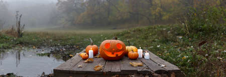 Halloween pumpkin burning in forest in foggy evening, holiday conceptの写真素材