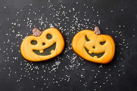 Halloween gingerbread biscuits on black background. Funny orange pumpkins.の写真素材