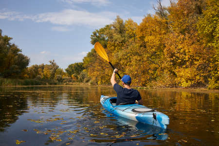 Man kayaking on lake in autumn. Active tourism.の写真素材