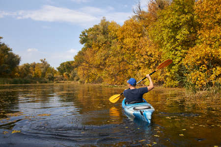 Man kayaking on lake in autumn. Active tourism.の写真素材
