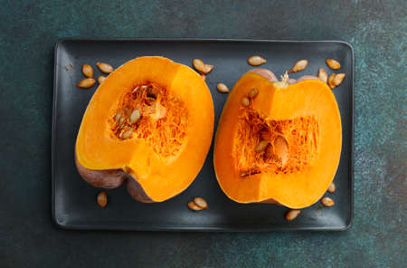 Pumpkin slices in plate on textured green background. Seasonal food.の写真素材