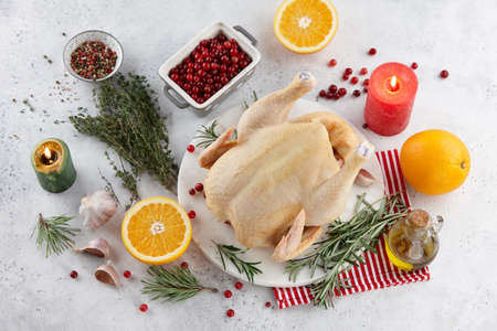 Raw turkey or chicken and ingredients for cooking on white table. Holiday preparation.の写真素材