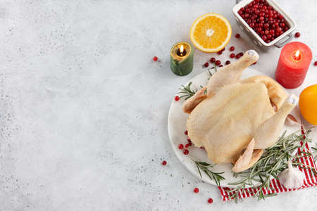 Raw turkey or chicken and ingredients for cooking on white table. Holiday preparation.の写真素材
