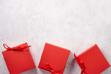 Red Christmas gift boxes on white textured backgroundの写真素材